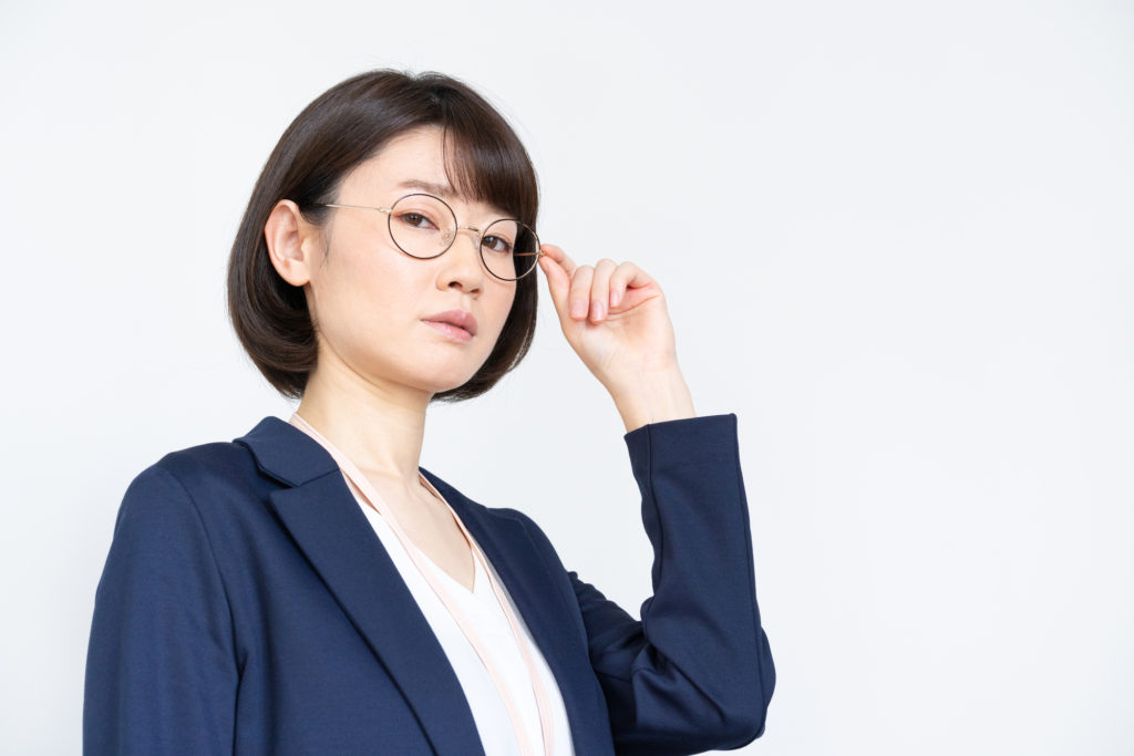 眼鏡に手を添えている女性のイメージ画像