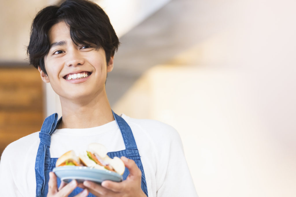 料理を運ぶさわやかな店員のイメージ