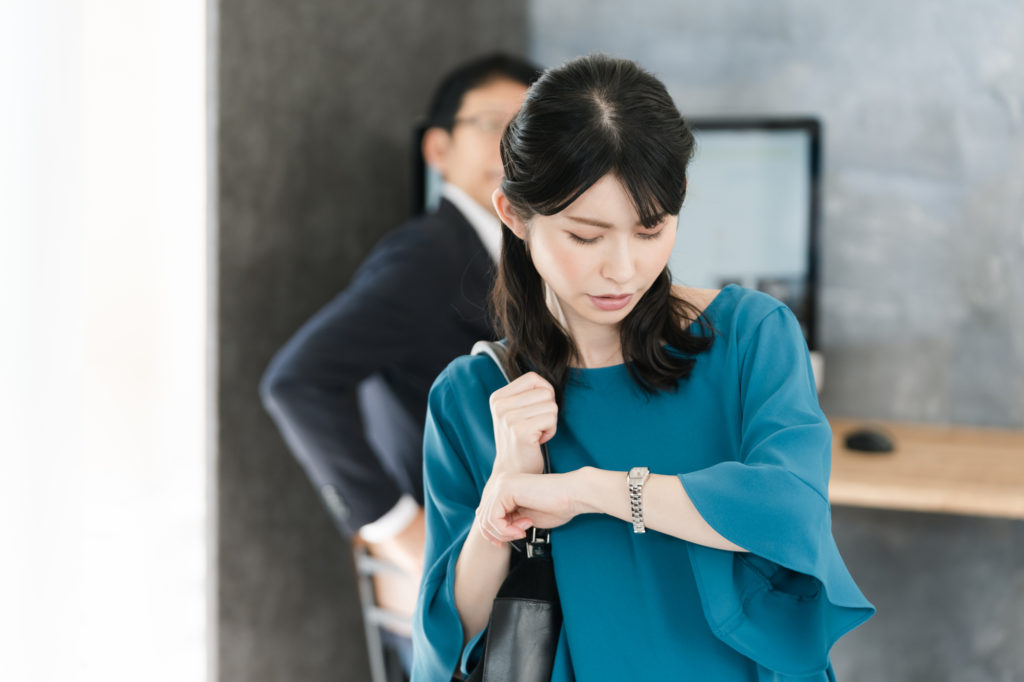 時計を気にする女性のイメージ