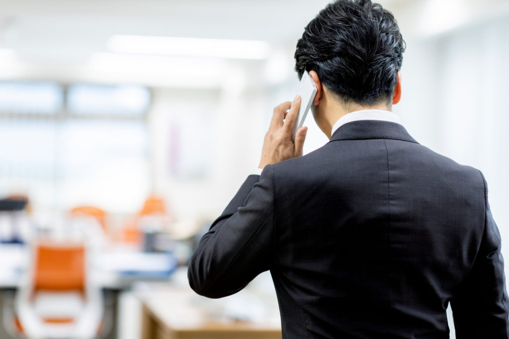 会社で電話をする男性